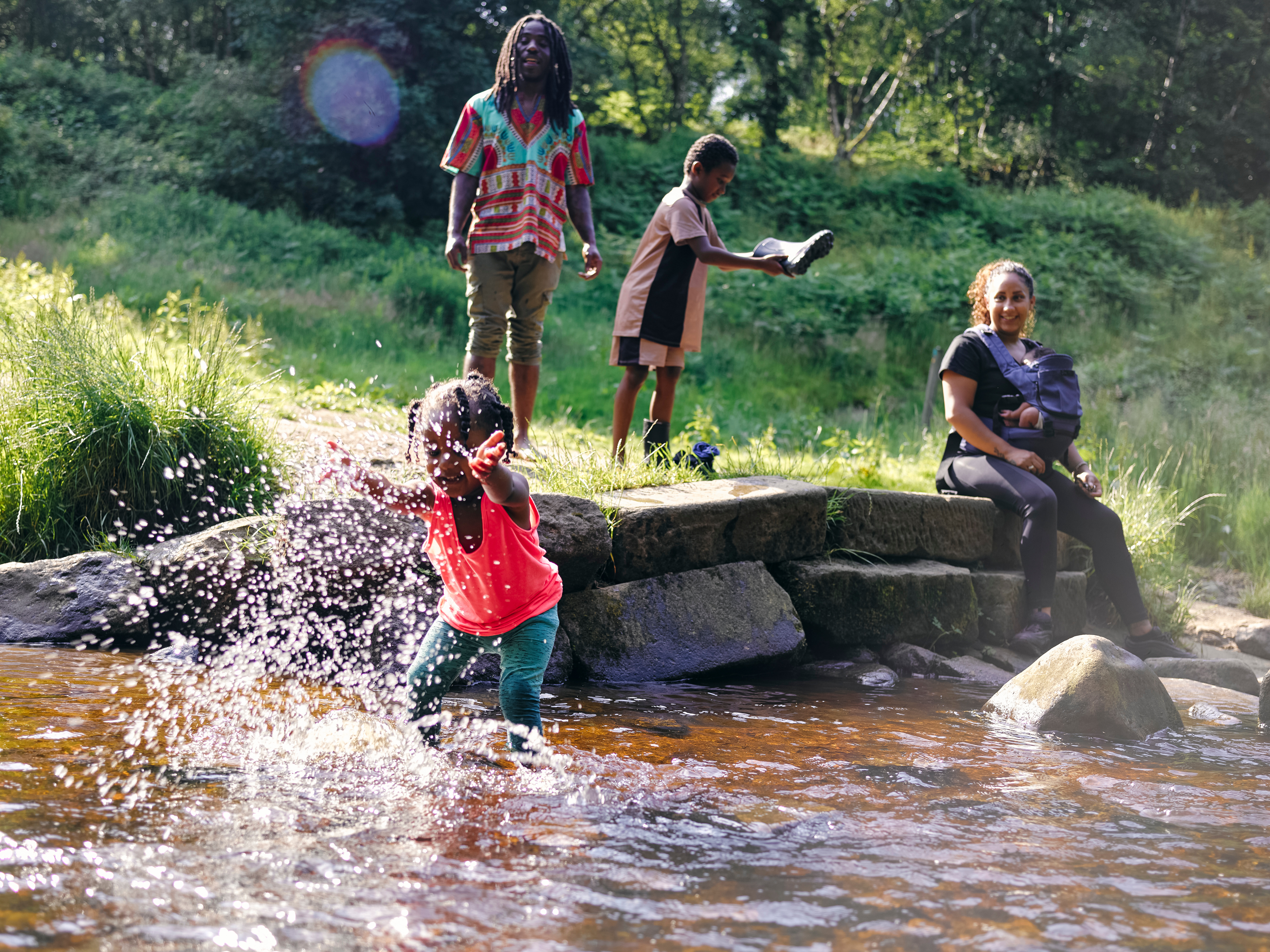 A family plays in a creek with splashing water